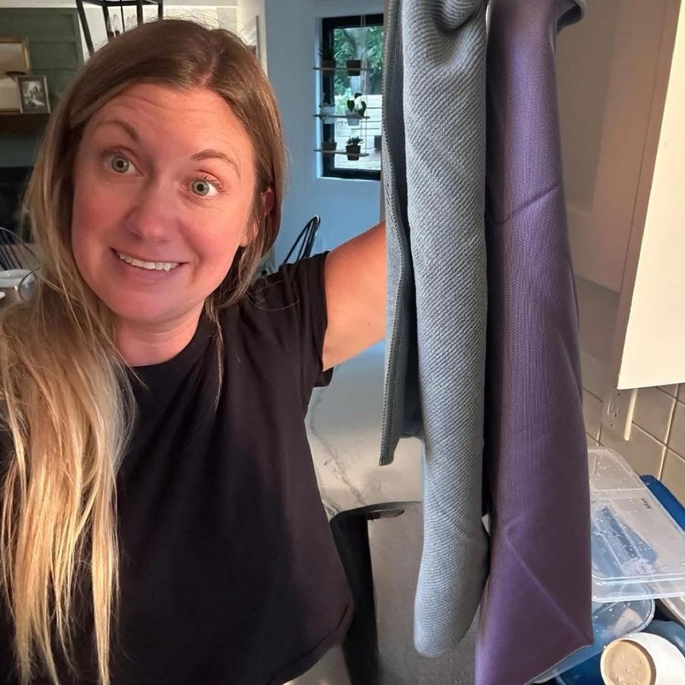 Laura in her kitchen holding Norwex cloths